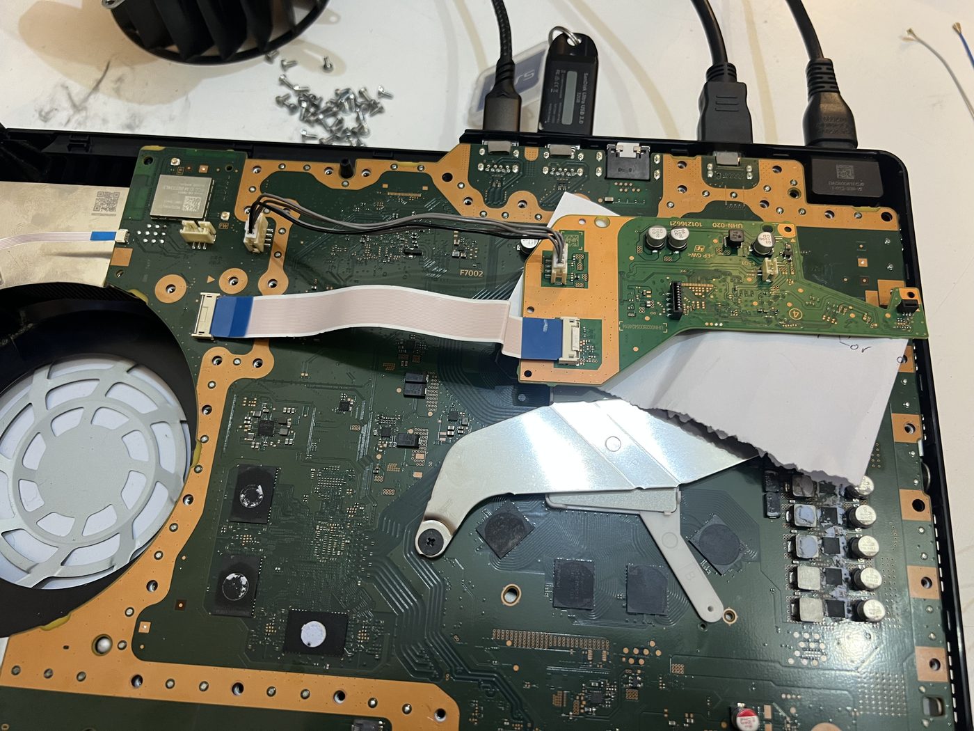 PS5 motherboard and UHN-020 Blu-ray daughterboard connected during bench testing