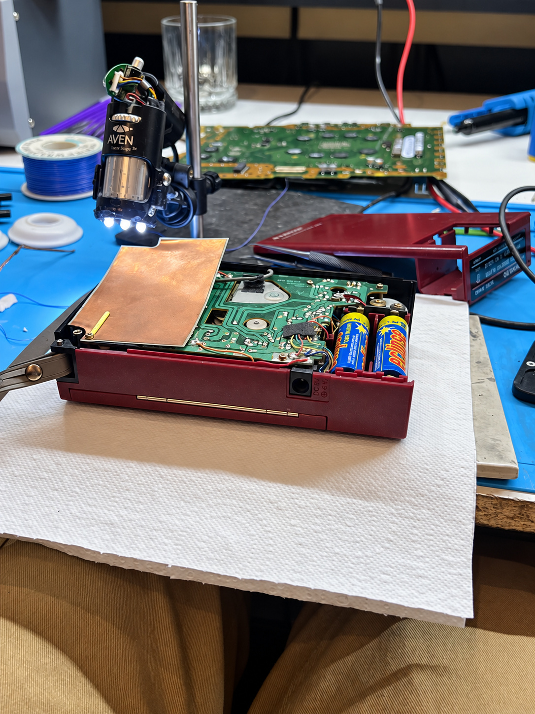 Open Sanyo M4440 cassette player on the bench during electrical diagnosis with batteries fitted