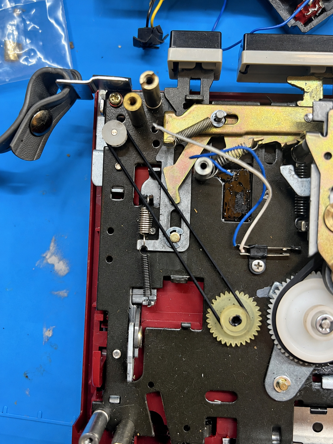 Close-up of the Sanyo cassette player’s exposed belt drive, pulleys and mechanical linkages